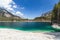 Gently sloping shore of the emerald Alpine mineralized Tovel lake surrounded by mountains under the blue sky,Â Ville d`Anaunia,